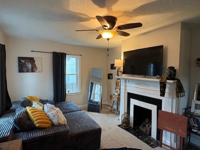 carpeted bedroom with a fireplace with flush hearth, baseboards, ceiling fan, and a textured ceiling