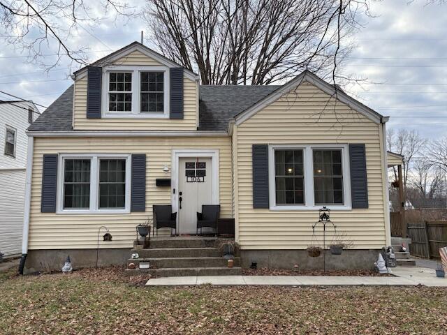 bungalow-style house featuring a shingled roof and fence