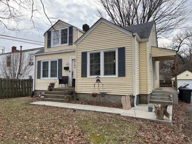 view of front of home with an outbuilding and fence