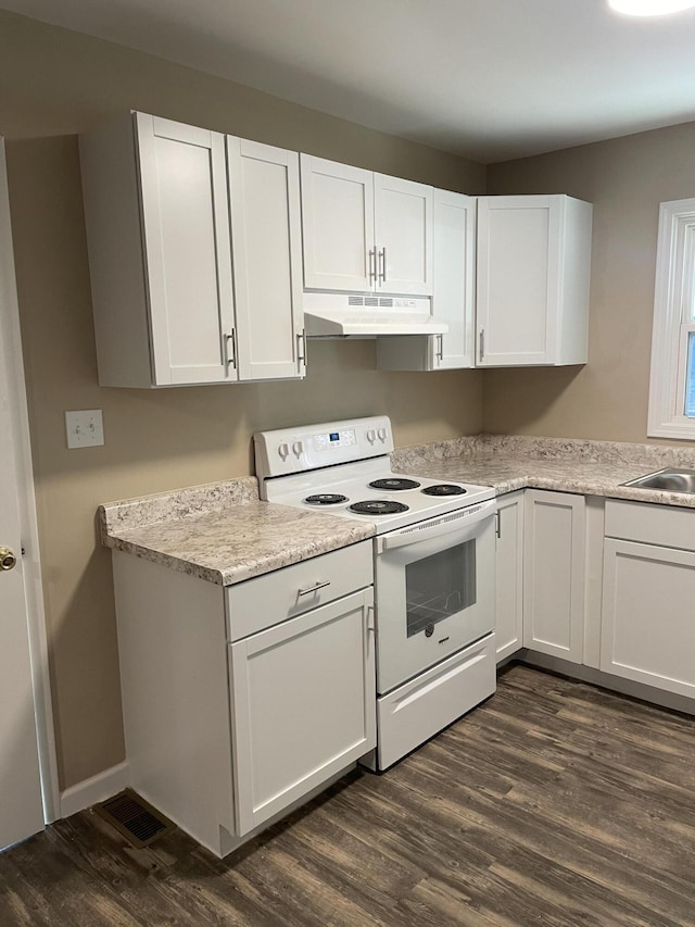 kitchen with under cabinet range hood, white electric range, dark wood-type flooring, white cabinetry, and light countertops