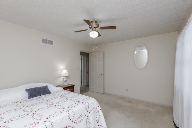 bedroom featuring a textured ceiling, light carpet, a ceiling fan, visible vents, and baseboards