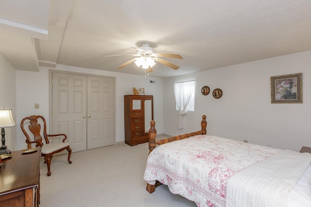 bedroom with light carpet, ceiling fan, and a closet