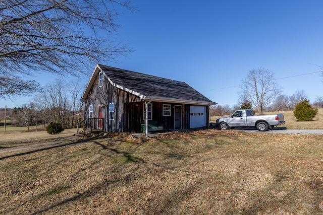 view of outbuilding with a garage, driveway, and an outbuilding