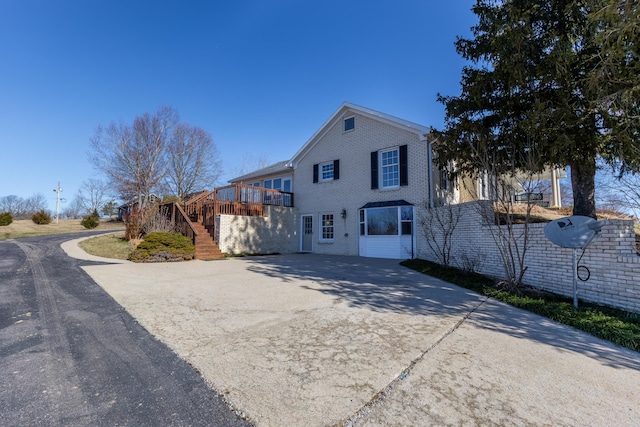 view of front of house with a wooden deck, stairway, and brick siding