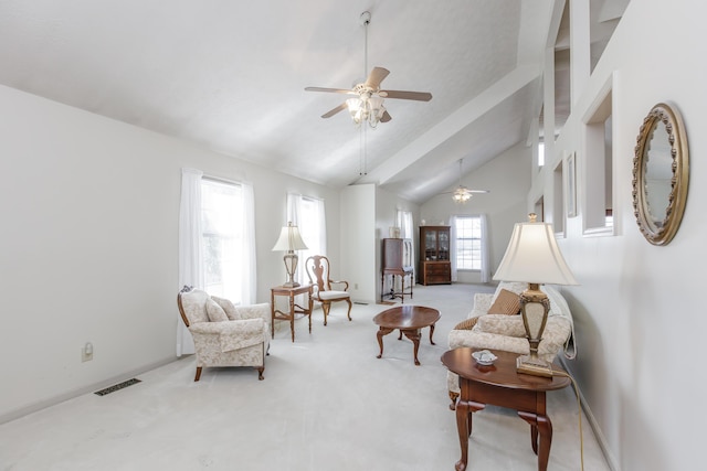 living area with high vaulted ceiling, light carpet, ceiling fan, and visible vents