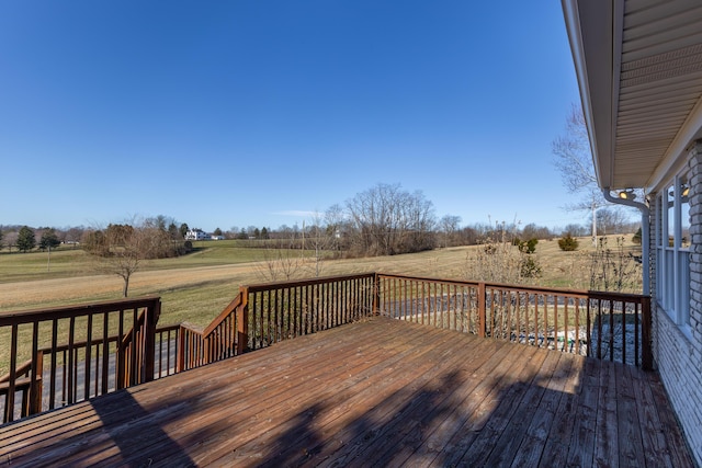 wooden deck featuring a yard and a rural view