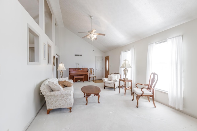 living room with ceiling fan, high vaulted ceiling, a textured ceiling, carpet flooring, and visible vents