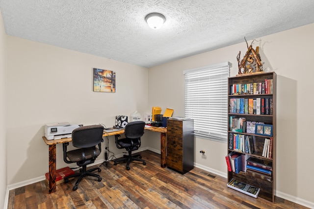 home office with visible vents, baseboards, a textured ceiling, and hardwood / wood-style floors