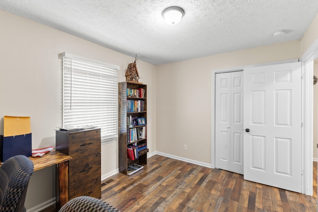 office with a textured ceiling, dark wood-type flooring, visible vents, and baseboards