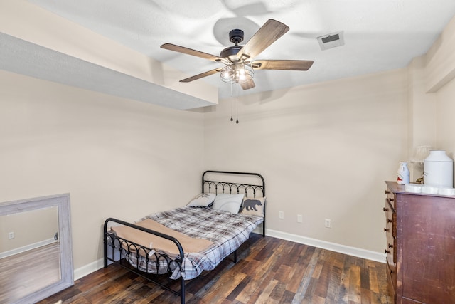 bedroom with a ceiling fan, wood-type flooring, visible vents, and baseboards