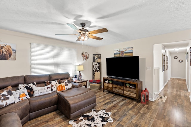 living room featuring a textured ceiling, hardwood / wood-style floors, a ceiling fan, and baseboards