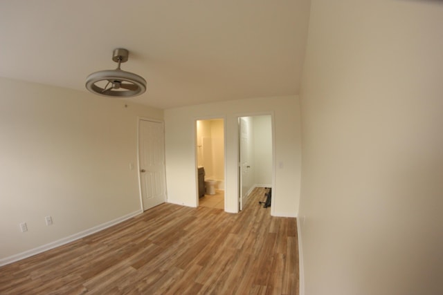 empty room with baseboards, a ceiling fan, and wood finished floors