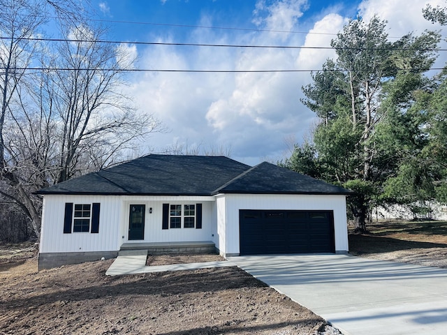 view of front of home featuring concrete driveway, roof with shingles, and an attached garage