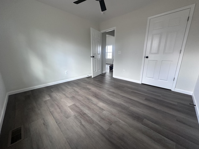 unfurnished bedroom featuring baseboards, visible vents, ceiling fan, and dark wood-style flooring