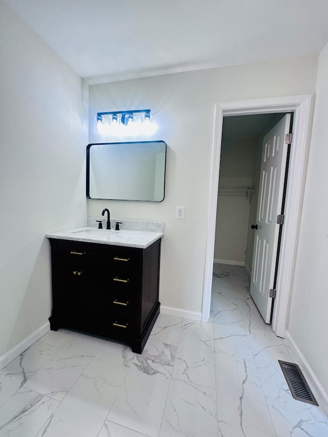 bathroom featuring marble finish floor, baseboards, visible vents, and vanity