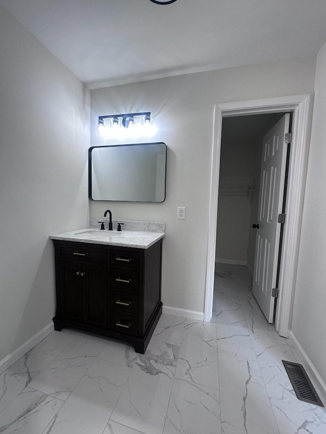 bathroom with marble finish floor, baseboards, visible vents, and vanity