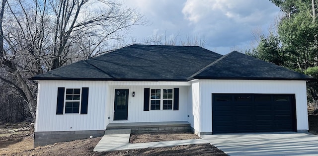 view of front of property with a garage, driveway, and roof with shingles