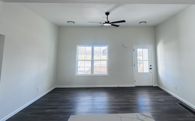 interior space featuring dark wood-style flooring, a ceiling fan, and baseboards