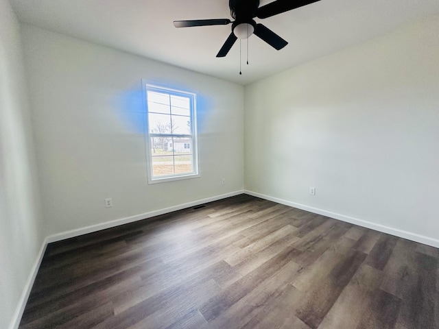 unfurnished room featuring a ceiling fan, dark wood-style flooring, visible vents, and baseboards