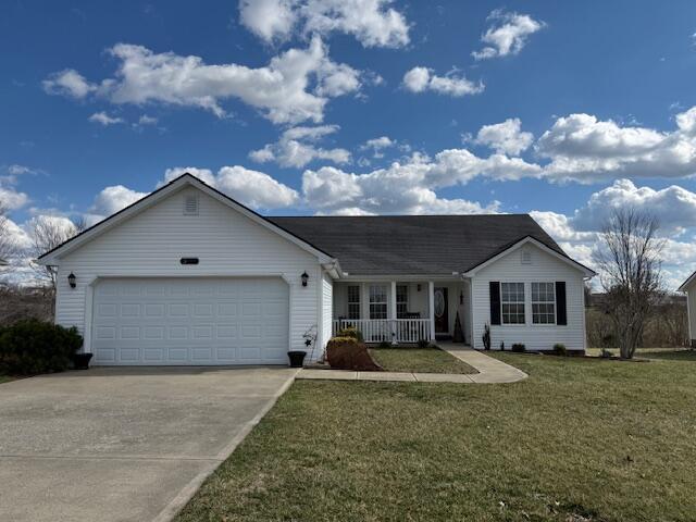 ranch-style house with a porch, a front yard, driveway, and an attached garage