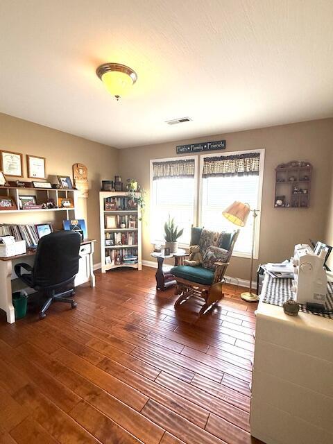 home office with hardwood / wood-style flooring, visible vents, and baseboards