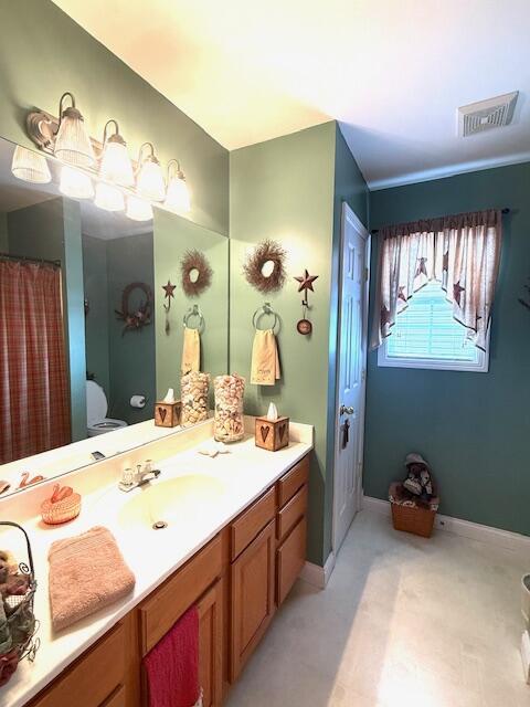 bathroom with toilet, baseboards, visible vents, and vanity