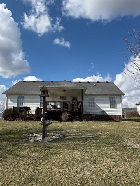 rear view of house featuring a lawn and a wooden deck