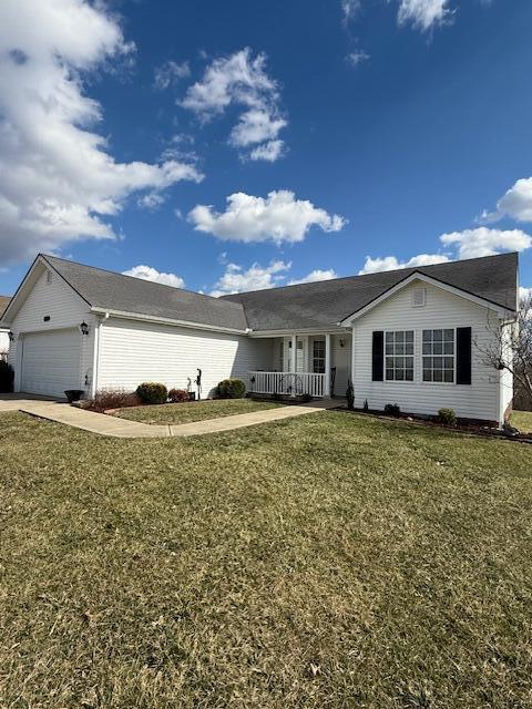 ranch-style home featuring concrete driveway, covered porch, an attached garage, and a front lawn