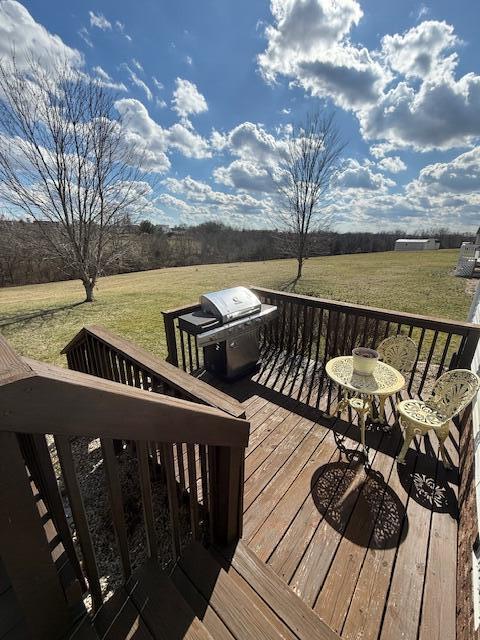 wooden terrace with a yard, a rural view, and grilling area