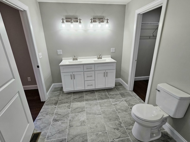 full bath with a sink, toilet, and baseboards