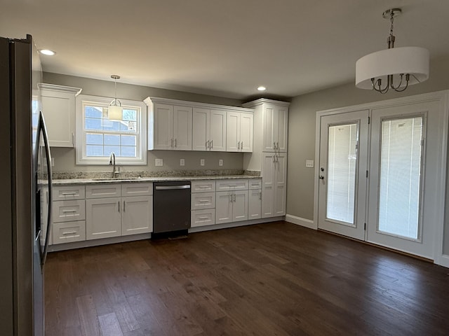 kitchen with light stone counters, dark wood-type flooring, a sink, white cabinetry, and appliances with stainless steel finishes