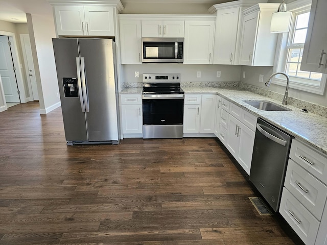 kitchen featuring stainless steel appliances, dark wood-style flooring, a sink, and white cabinets