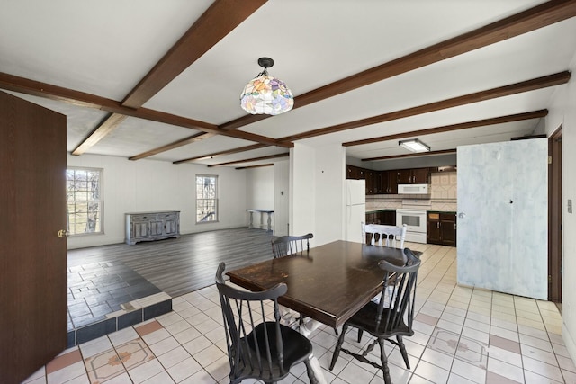 dining space featuring beam ceiling and light tile patterned flooring