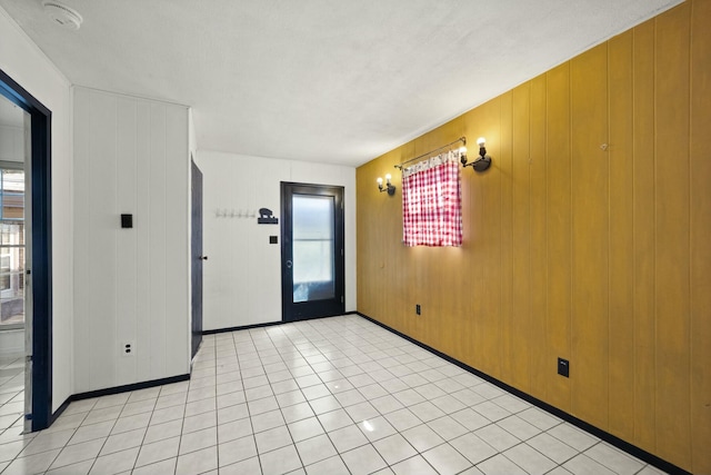 foyer entrance featuring a wealth of natural light, baseboards, and light tile patterned floors