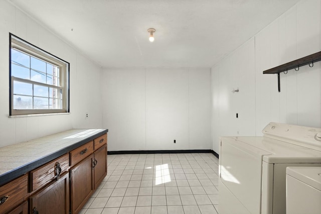 washroom featuring cabinet space, light tile patterned flooring, and independent washer and dryer