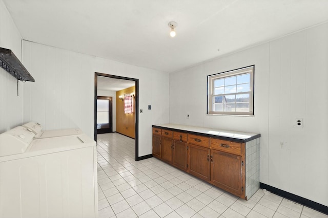 interior space featuring cabinet space, baseboards, separate washer and dryer, and light tile patterned flooring