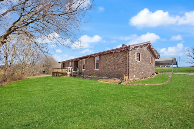 exterior space featuring brick siding, a yard, a chimney, and a wooden deck