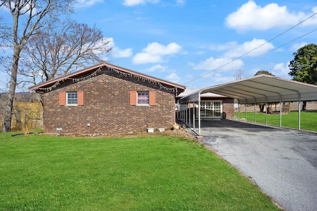 exterior space with driveway, brick siding, crawl space, a carport, and a front yard