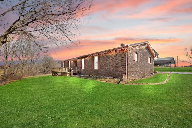 property exterior at dusk with crawl space, a yard, a deck, and brick siding