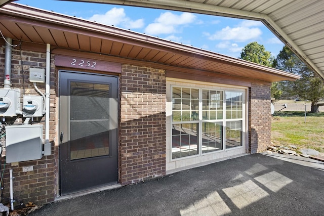 doorway to property featuring brick siding