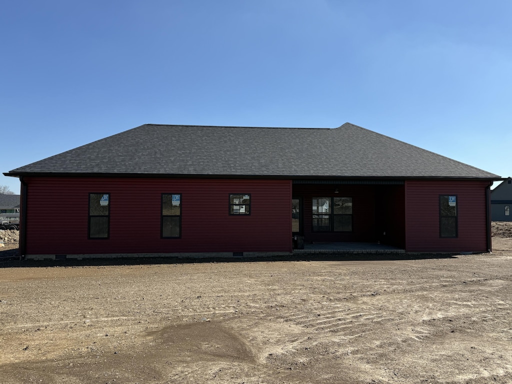 rear view of property featuring a shingled roof and crawl space