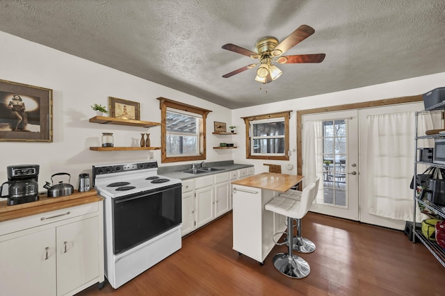 kitchen with open shelves, white range with electric cooktop, white cabinets, wooden counters, and a sink