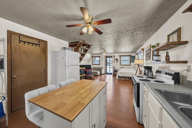 kitchen with dark wood-type flooring, white appliances, white cabinetry, and open shelves