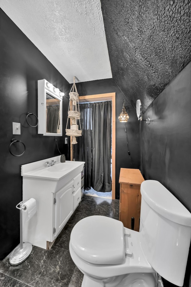 bathroom with toilet, marble finish floor, a textured ceiling, and lofted ceiling