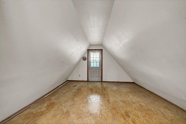 bonus room with vaulted ceiling and a textured ceiling