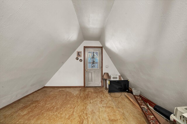 additional living space with lofted ceiling, a textured ceiling, and visible vents