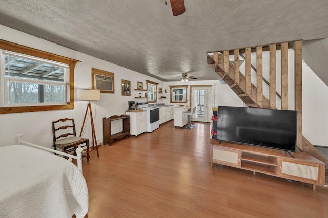 interior space with multiple windows, dark wood finished floors, a textured ceiling, and a wall mounted air conditioner