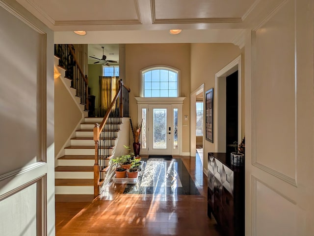 entrance foyer featuring stairway, baseboards, ornamental molding, and wood finished floors