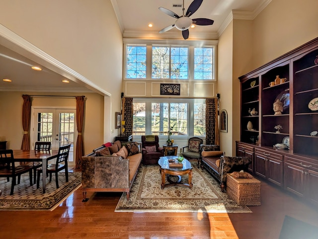 living room with plenty of natural light, dark wood-type flooring, crown molding, and french doors