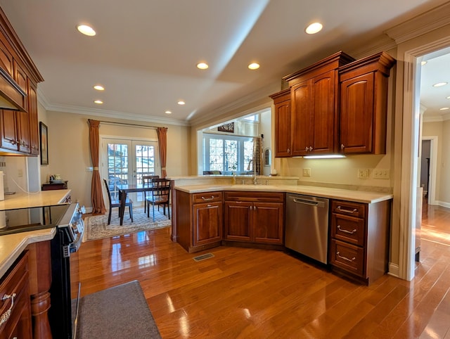 kitchen featuring wood finished floors, a sink, light countertops, ornamental molding, and dishwasher